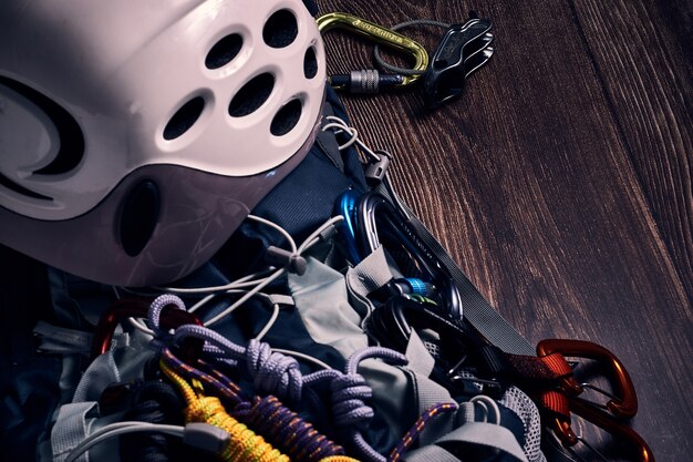 Closeup shot of many colorful climbing carabiners and knots on a wooden surface