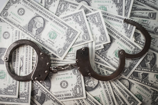 Closeup shot of metal handcuffs and dollars