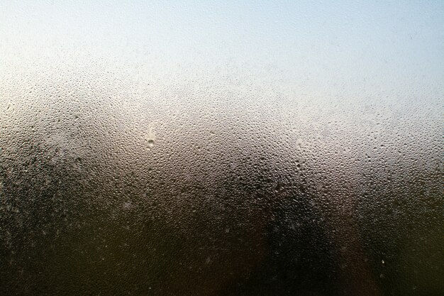 Снимок крупным планом туманного окна с каплями воды