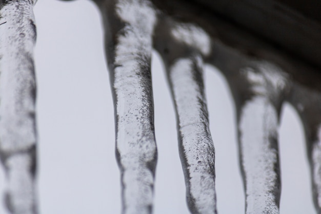 Free photo closeup shot of numerous icicles hung from the building rooftop