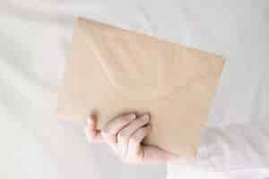 Бесплатное фото Снимок крупным планом руки человека, держащего конверт