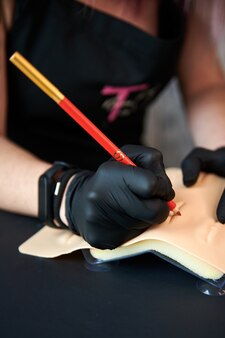 문신 기계로 입술을 붉히는 절차를 준비하는 여성의 클로즈업 샷