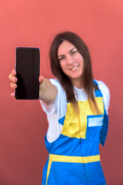Бесплатное фото Крупным планом снимок молодой женщины с ее смартфоном, позирует на камеру