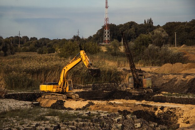 Closeup shot of an ongoing construction  with tracks and a bulldozer on an  abandoned land