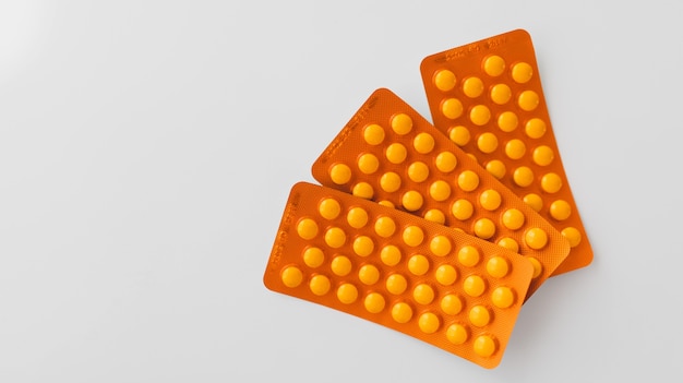 Closeup shot of orange pills on the white background