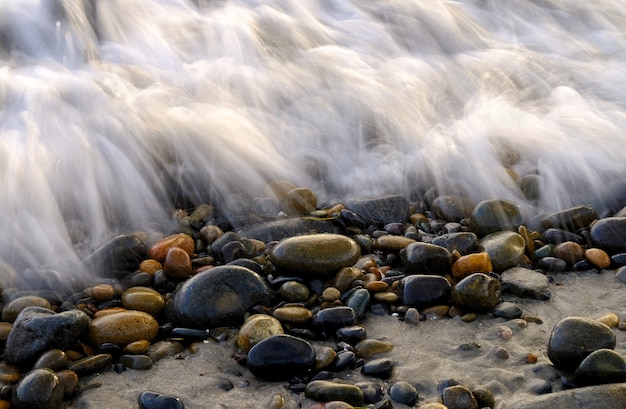 Closeup shot of pebbles covered with seafoam