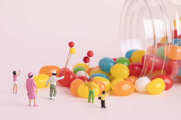 Closeup shot of people figures with balloons and colorful candies - concept of children's day