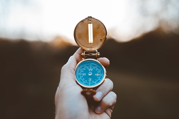 Free photo closeup shot of a person holding a compass with a burred background