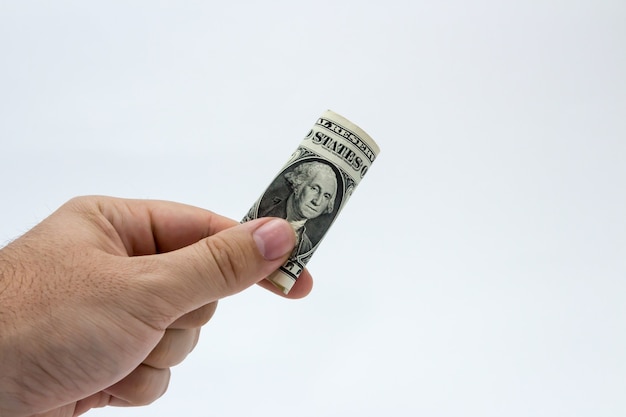Colpo del primo piano di una persona in possesso di una banconota da un dollaro su uno sfondo bianco