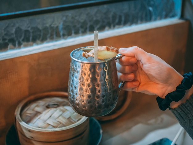 Closeup shot of a person holding a ginger Asian drink