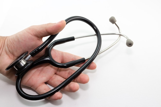 Closeup shot of a person holding a stethoscope over a white surface