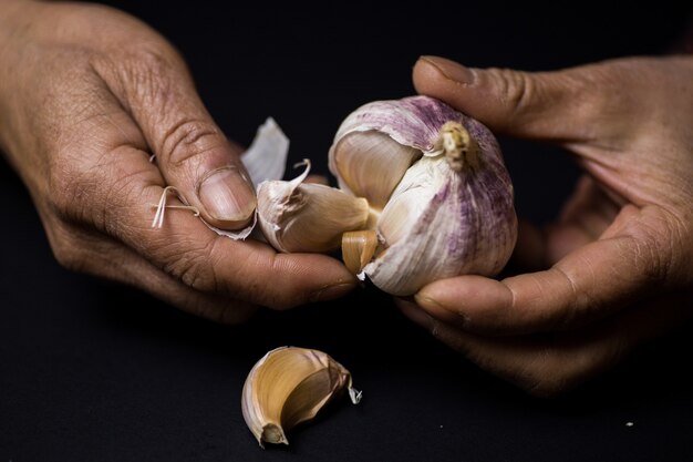 Closeup shot of a person peeling garlic