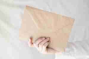 Free photo closeup shot of a person's hand holding an envelope