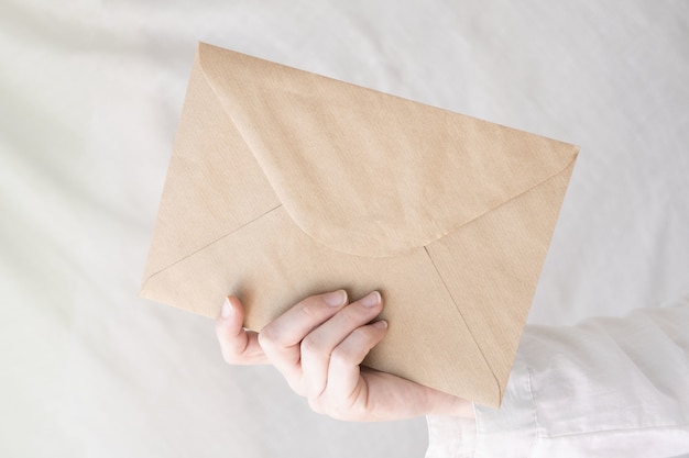 Closeup shot of a person's hand holding an envelope