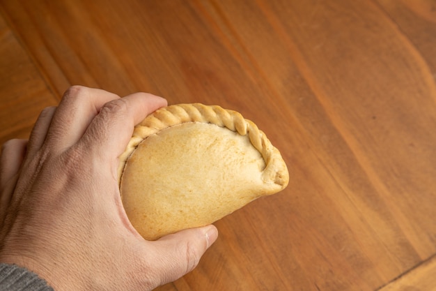 Closeup shot of a person's hand holding a homemade delicious dumpling