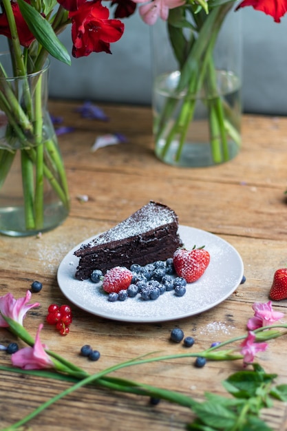 Closeup shot of a piece of brownie cake with blueberries and strawberries