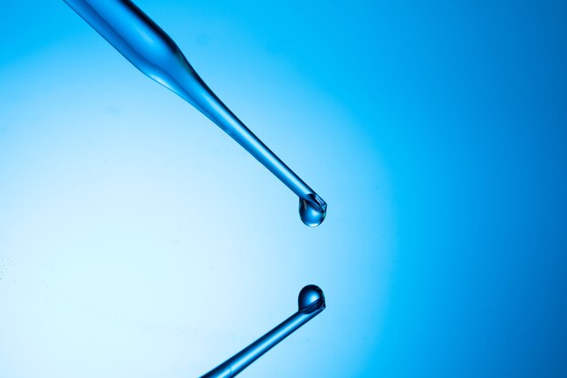 Closeup shot of a pipette tip with a liquid droplet