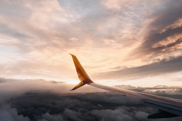 Closeup shot of a plane wing in a pinkish sky