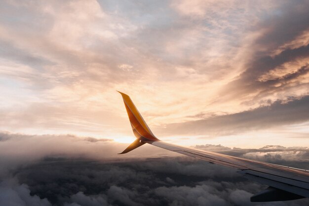 Closeup shot of a plane wing in a pinkish sky