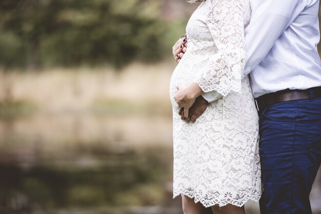 Closeup shot of a pregnant couple with their hands on the belly
