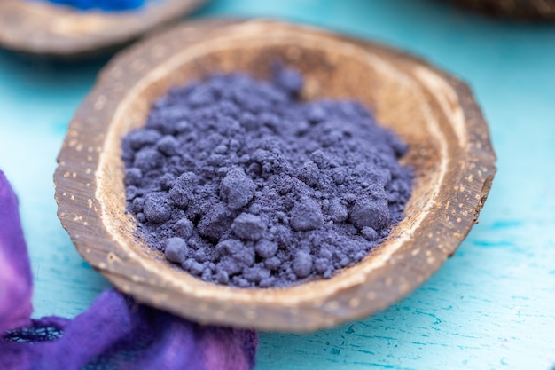 Free photo closeup shot of  purple food coloring powder in a small coconut plate