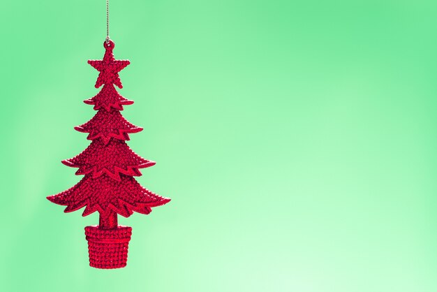 Крупным планом снимок красной вязанной вешалки для елки на светло-зеленом фоне
