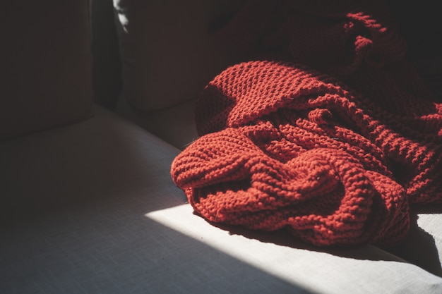 Free photo closeup shot of a red textile on a wooden surface illuminated with the sunlight