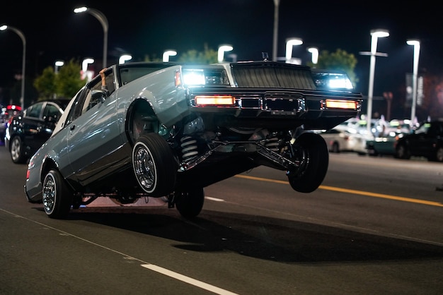 Снимок ретро-автомобиля с задними колесами на земле на улице ночью крупным планом