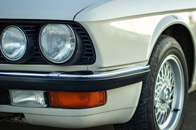 Closeup shot of the round headlights of a white vintage classic car