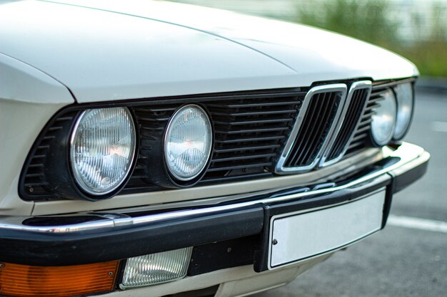 Closeup shot of the round headlights of a white vintage classic car