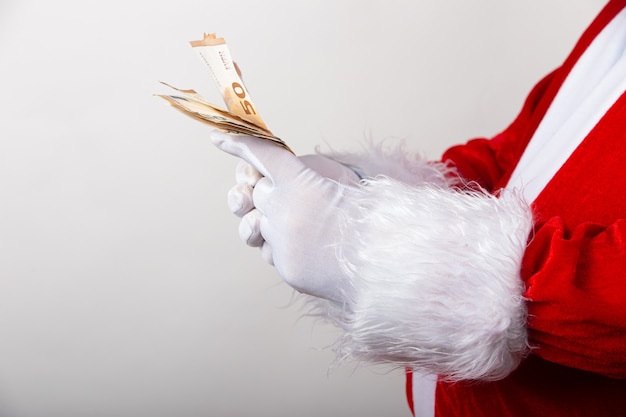 Closeup shot of Santa Claus holding euro bills