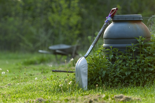 Closeup shot of a shovel in the garden with trees – Free Download
