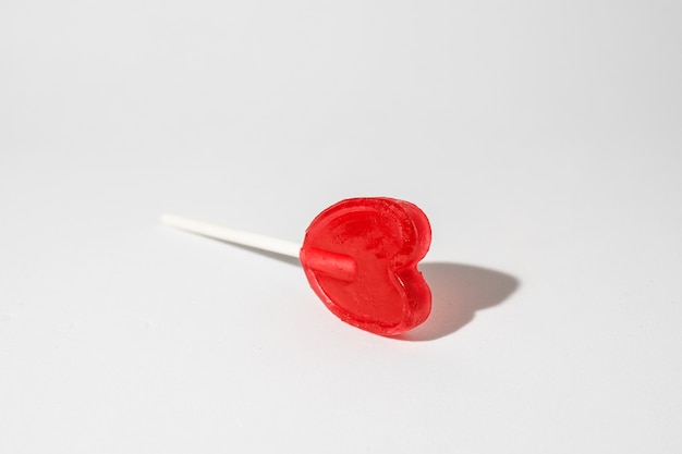 Closeup shot of a single heart-shaped lollipop on a white background