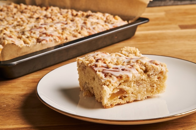 Closeup shot of a slice of a delicious apple pie on a plate on a wooden table