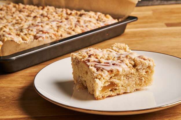 Closeup shot of a slice of a delicious apple pie on a plate on a wooden table