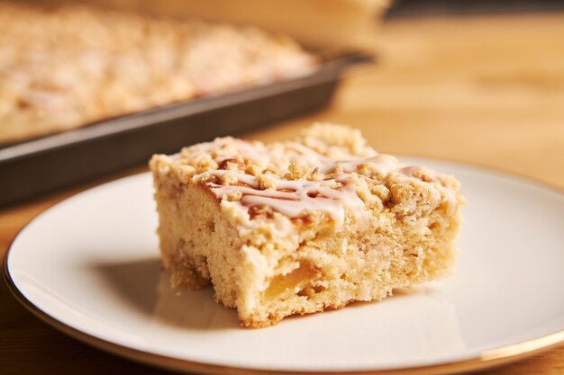 Closeup shot of a slice of a delicious apple pie on a plate on a wooden table