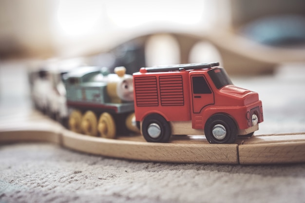 Closeup shot of a small toy car on a wooden train track Free Photo