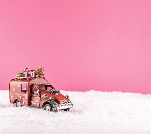 雪の上のクリスマスの装飾のためのおもちゃの車のクローズアップショット
