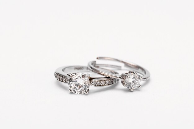 Closeup shot of two diamond rings on a white surface