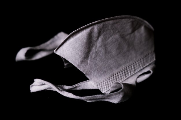 Closeup shot of a used face mask for protection from corona virus isolated on black