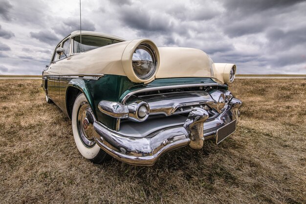 Closeup shot of a vehicle on a dry field under a cloudy sky