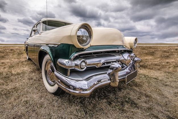 Closeup shot of a vehicle on a dry field under a cloudy sky