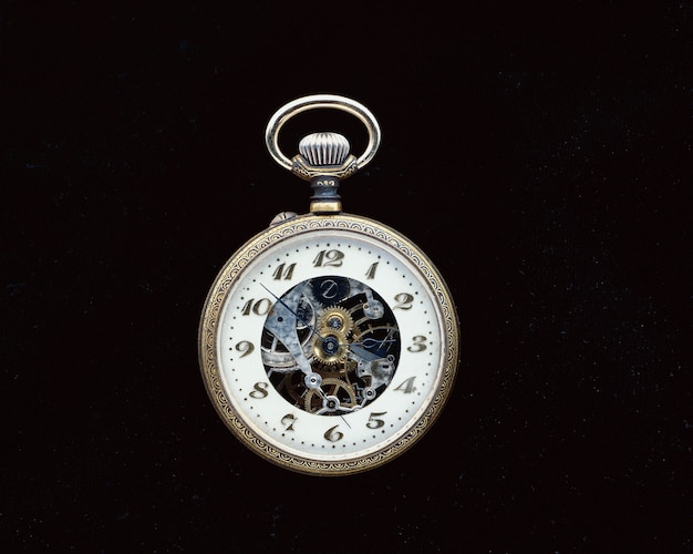 Closeup shot of a vintage pocket watch on a black surface