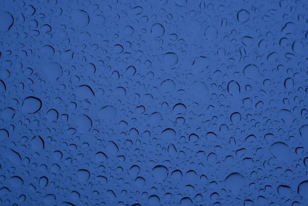 파란색 유리에 물 크고 작은 방울의 근접 촬영 샷-배경에 대한 완벽한