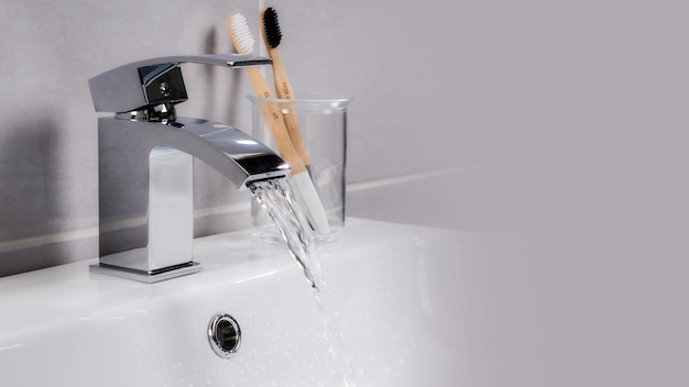 Closeup shot of water flowing from a basin mixer tap in the bathroom