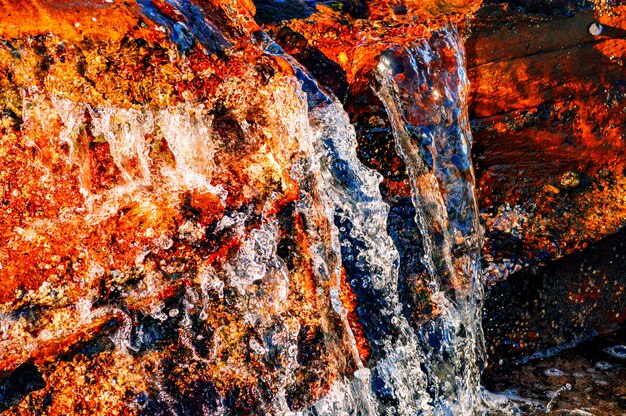 Closeup shot of the water pouring through the rocks