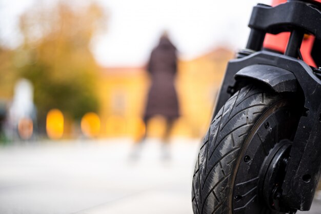Closeup shot of a wheel of a motorcycle with a person standing in the back