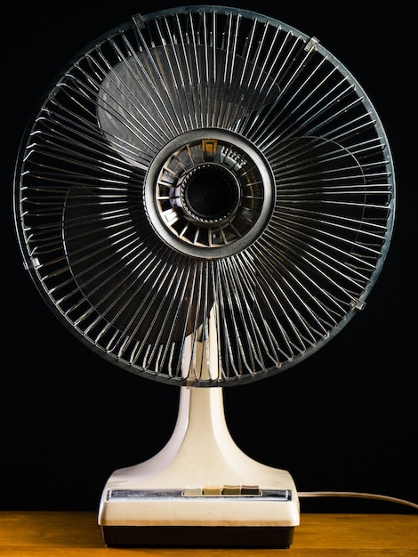 Free photo closeup shot of  a white desk fan on a wooden  table