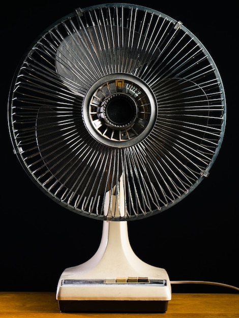 Белый настольный вентилятор крупным планом на деревянном столе
