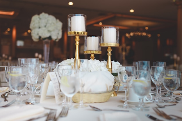 Съемка крупного плана белых свечей столба в канделябрах на таблице свадьбы